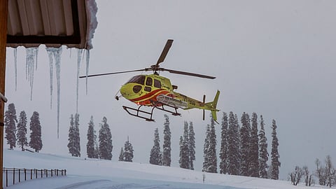 A helicopter carries body of a foreign skier after an avalanche hit struck the Kongdoori slopes trapping several skiers under its debris, in Gulmarg.