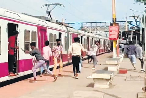 Two groups of college students throw stones and bottles at each other at Pattaravakkam railway station on Wednesday