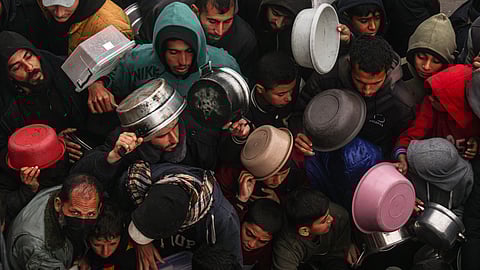 Palestinians receive food rations at a donation point at a camp for internally displaced people in Rafah in the southern Gaza Strip on February 2, 2024.