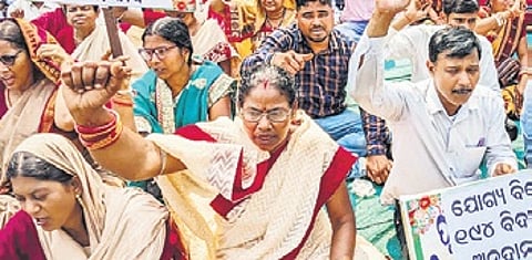 Teachers under the banner of Odisha Secondary School Teachers Association sit on a protest at Mahatma Gandhi Marg in Bhubaneswar on Monday.
