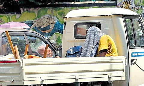 To protect himself from the heat, a labourer in an open pick-up shields his head with a cloth at LMS Junction in Thiruvana- nthapuram.