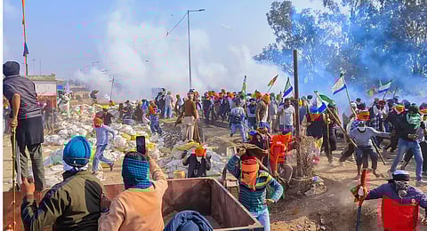 Farmers look for cover after police fired tear gas at them during their 'Delhi Chalo' march, near the Punjab-Haryana Shambhu border, in Patiala district, Wednesday, Feb. 21, 2024.