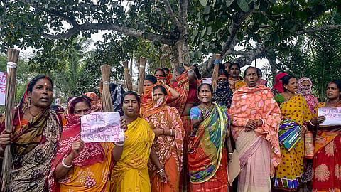 Women holding posters stage a protest in Sandeskhali.