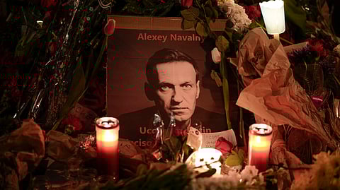 Flowers and candles are laid around a photo of Russian opposition leader Alexei Navalny during a rally to commemorate him, at Rome's Piazza del Campidoglio city council square, Monday, Feb. 19, 2024