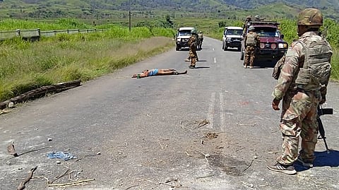 This handout picture released by the Royal Papua New Guinea Constabulary on February 19, 2024 shows a dead body on a road as officials patrol near the town of Wabag, 600 kilometres northwest of the capital Port Moresby.