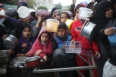 Palestinians line up for free food distribution during the ongoing Israeli air and ground offensive in Khan Younis, Gaza Strip.