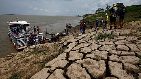 Residents of a riverside community carry food and containers of drinking water after receiving aid due to the ongoing drought in Careiro da Varzea, Amazonas state, Brazil, Oct. 24, 2023.