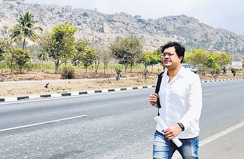 Farooq Junaidi walks on the highway linking Kolar with Bengaluru, as he makes his way to the state capital, to seek an audience with the chief minister