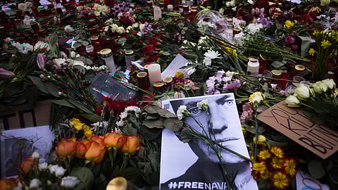 A photo of Russian opposition leader Alexei Navalny lays between flowers and candles.