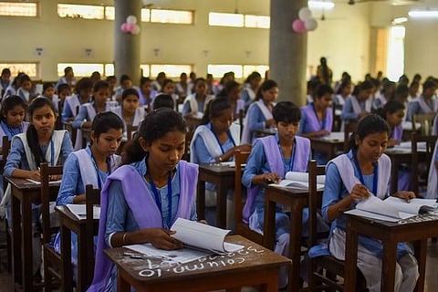 As CHSE plus two exams begins, students at an examination venue write their first paper at Ramadevi Women's University in Bhubaneswar