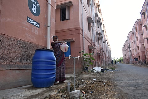 A woman fetching water from water storage drum as there is no proper water facilities at Keeranatham housing unit in Coimbatore.