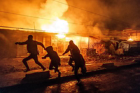 People run for cover following a series of explosions in the Embakasi area of Nairobi on February 2, 2024.