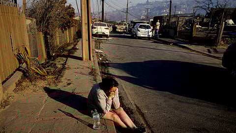 A woman cries losing a friend who died after a forest fire reached Villa Independencia neighborhood in Vina del Mar, Chile