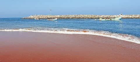 Fishing boats pass through the narrow channel on the harbour mouth of Muthalapozhi where accumulation of sand is posing a threat