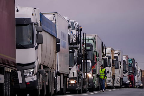 Trucks wait a blocked road in Corral de Almaguer, near Toledo, central Spain, Friday, Feb. 9, 2024. Thousands of Spanish farmers on tractors are blocking highways and some city streets in a fourth consecutive day of protest against European Union agriculture policies.