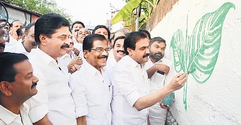 KC(M) chairman Jose K Mani launches the election campaign of LDF candidate Thomas Chazhikadan by painting the party symbol on a wall.