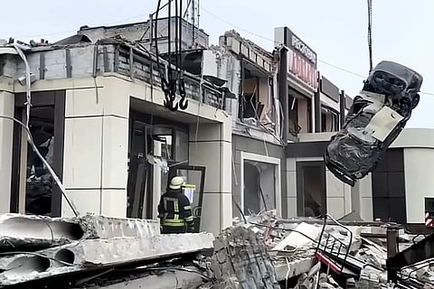 Russian Emergency Ministry employees work at the side of a collapsed bakery after an attack of Ukrainian troops, that Russian officials in Luhansk said was conducted by Ukrainian forces.