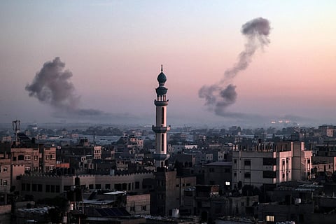 A picture taken from Rafah shows smoke billowing during Israeli bombardment over Khan Yunis in the southern Gaza Strip at sunrise on February 11, 2024.