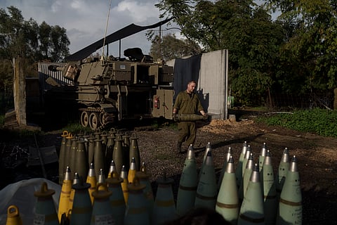 An Israeli soldier carries a howitzer shell near the border with Lebanon, in northern Israel, Thursday, Jan. 11, 2024.