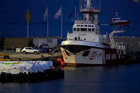 Aid packages are seen left, on a platform near to the docked ship belonging to the Open Arms aid group, as it prepares to ferry some 200 tonnes of rice and flour directly to Gaza, at the port in Larnaca, Cyprus, Sunday, March 10, 2024.