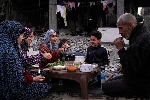 The Palestinian Al-Naji family eats an iftar meal, the breaking of fast, amidst the ruins of their family house, on the first day of the Muslim holy fasting month of Ramadan.