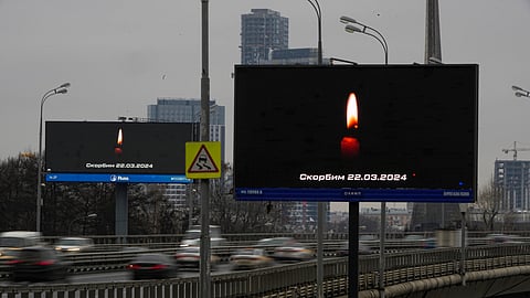Traffic on the highway passes a message displayed on a billboard that reads: "We Mourn 03.22.2024" in Moscow, Russia.