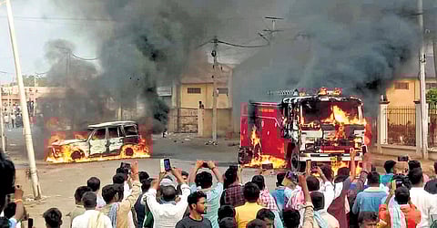 Protesters torch a police vehicle and a fire tender at Byadgi town of Haveri on Monday