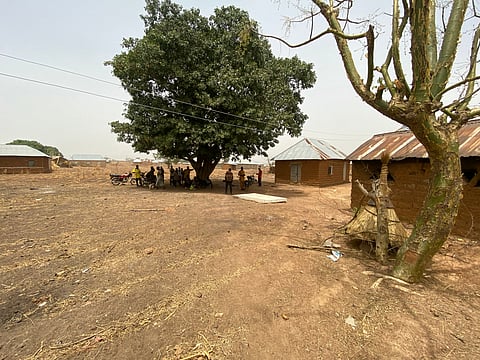 Residents of Tantatu Ward village stand outside their home in the Kajuru Station district.