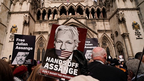 Demonstrators hold placards after Stella Assange, wife of Wikileaks founder Julian Assange, released a statement outside the Royal Courts of Justice, in London, Tuesday, March 26, 2024.