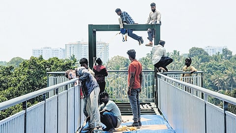 Workers giving finishing touches to the glass bridge that will be opened for the public next week at Akkulam Tourist Village in Thiruvananthapuram