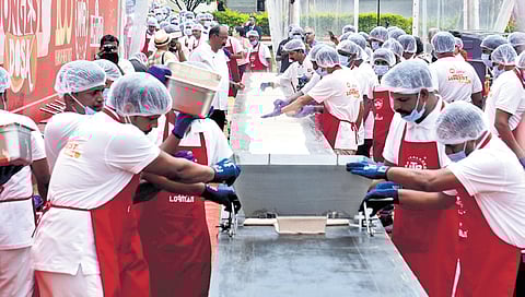 Chefs craft the 123-ft dosa using MTR’s signature red rice dosa batter, as part of the food brand’s 100-year celebrations, in Bengaluru on Saturday