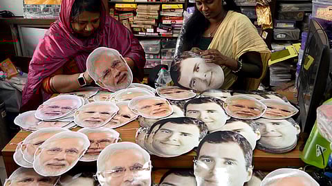 Shopkeepers arrange the facemasks with the photos of Narendra Modi and Rahul Gandhi for sale ahead of the Lok Sabha election.