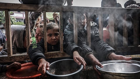 Displaced Palestinian children gather to receive food at a government school in Rafah in the southern Gaza Strip on February 19, 2024, amid the ongoing battles between Israel and the militant group Hamas.
