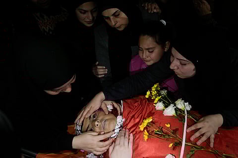 Mourners gather around the body of Mohammed Zeid, 13, during his funeral in Jalazoun refugee camp, West Bank,