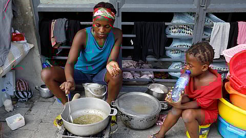Woman cooks at shelter for families displaced by gang violence, in Port-au-Prince, Haiti.