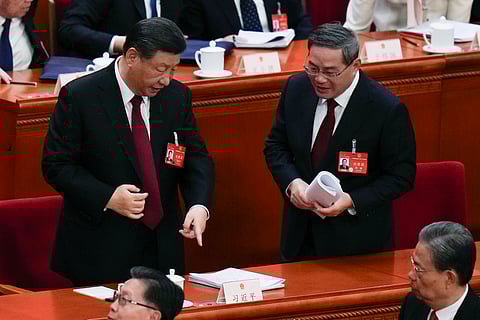 Chinese President Xi Jinping, left, chats with Chinese Premier Li Qiang after the opening session of the National People's Congress (NPC) at the Great Hall of the People in Beijing, China, Tuesday, March 5, 2024.