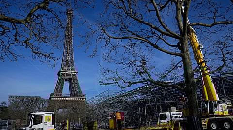 Workers build the stands for the upcoming summer Olympic Games on the Champ-de-Mars, just beside the Eiffel Tower, Friday, March 22, 2024 in Paris.