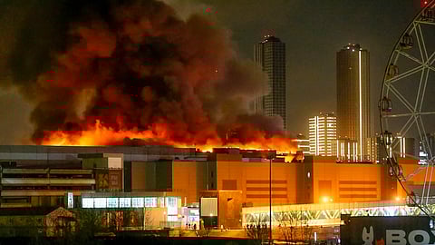 A massive blaze is seen over the Crocus City Hall on the western edge of Moscow, Russia, Friday, March 22, 2024. Several gunmen have burst into a big concert hall in Moscow and fired automatic weapons at the crowd, injuring an unspecified number of people and setting a massive blaze in an apparent terror attack.