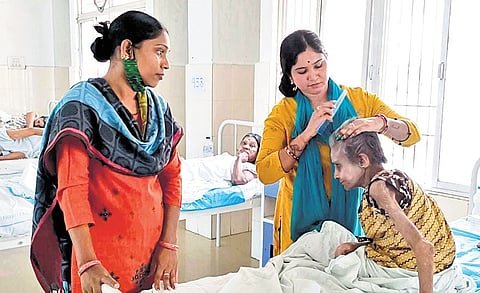Minu and Sukamati attending to a patient at the destitute ward of MKCG MCH
