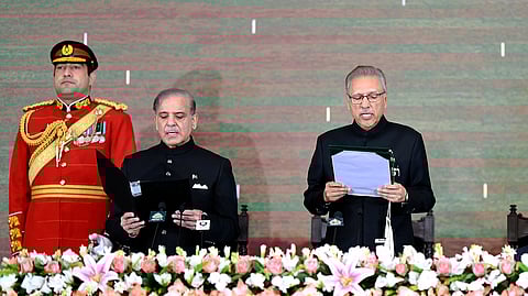In this photo released by the Pakistan's President Office, President Arif Alvi, right, administers the oath of office to newly elected Prime Minister Shehbaz Sharif during a ceremony at the Presidential Palace, in Islamabad, Pakistan