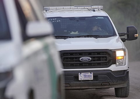 A US customs and border protections agent drives away from the site where a helicopter crashed in a field on Friday, March 8, 2024.