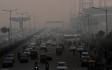 Vehicles ply on a road amid low visibility due to smog, in Ghaziabad.