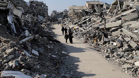 Palestinians walk through the destruction from the Israeli offensive in Jabaliya refugee camp in the Gaza Strip on Thursday, Feb. 29, 2024.