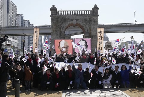 South Koreans wave their national flags during a ceremony to celebrate the March First Independence Movement Day in front of the Independence Gate in Seoul, South Korea, Friday, March 1, 2024.