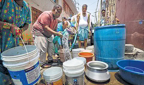 People collect drinking water from a tanker in Bengaluru on Monday
