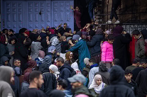 Palestinian people struggle to buy bread from a bakery in Rafah, Gaza Strip.