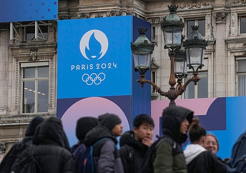 Youth gather at Paris City Hall where a Paris 2024 Olympic sign is displayed in Paris, Tuesday, March 5, 2024.