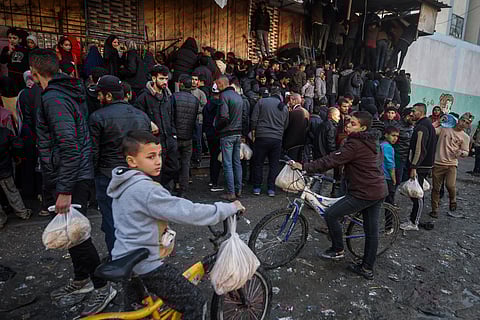 Palestinian crowds struggle to buy bread from a bakery in Rafah, Gaza Strip, Monday, Feb. 19, 2024.