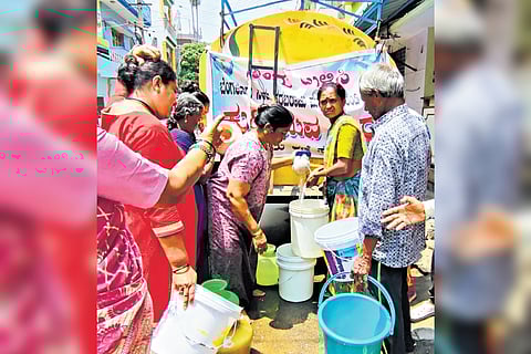 Residents fill up buckets and pots with precious drinking water from a tanker in Bapujinagar, Bengaluru, on Friday
