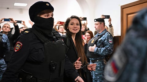 Antonina Favorskaya is escorted by a police officer to the courtroom in the Basmanny District Court in Moscow, Russia